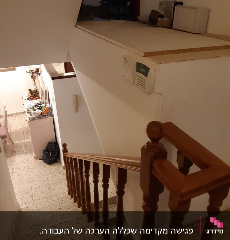 מעקה עץ במדרגות עם לוח מקשים על הקיר